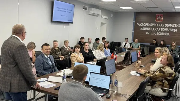 Аудитория слушает доклад, на экране слайд о функциональной нейрохирургии